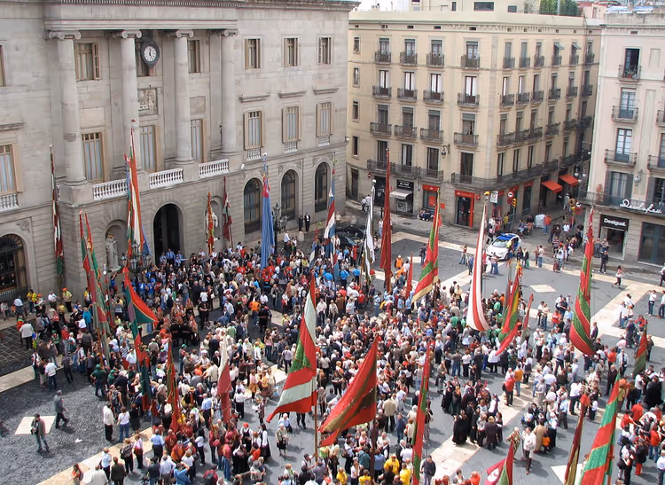 Folkemengde med flagg på Plaça de Sant Jaume