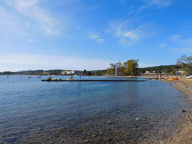 Kiezelstrand en helder water van Ipsos Bay