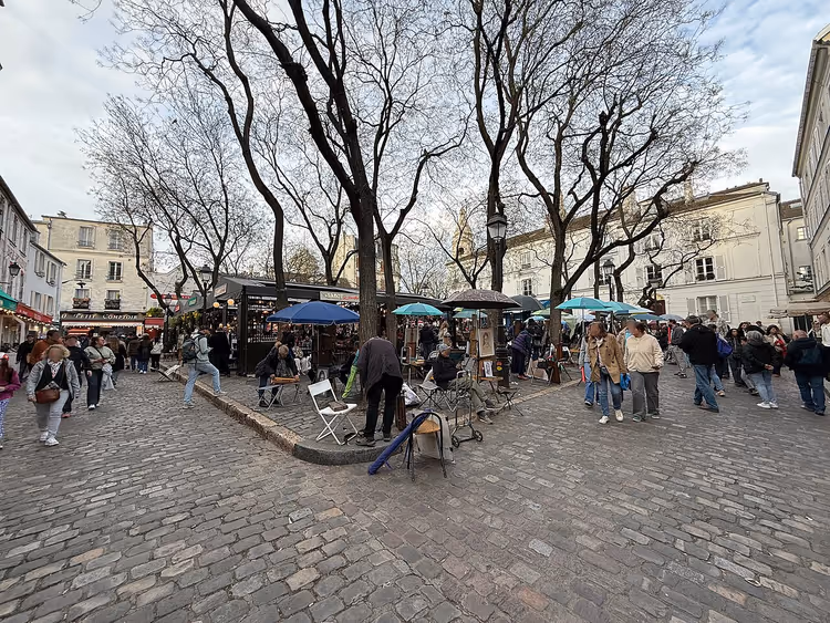 Paris'teki Place du Tertre'de şövale başında ressamlar