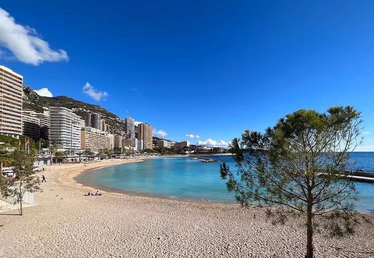 Larvotto-stranden med havet og høyhusene i Monaco