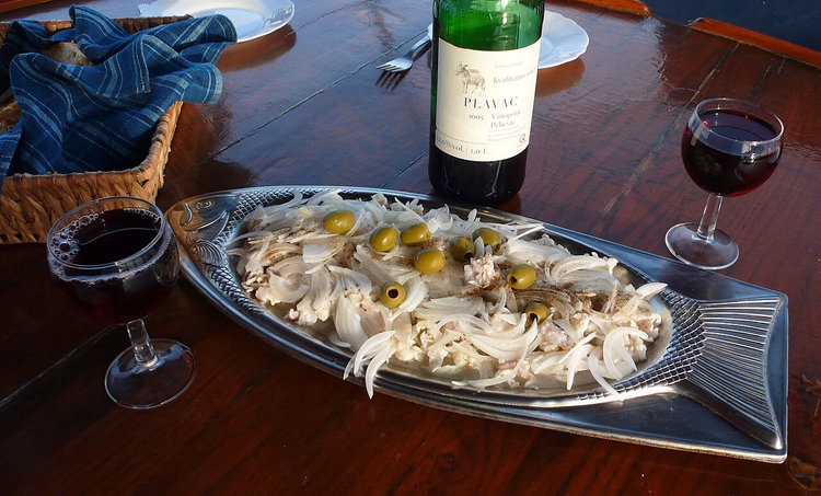 flaske med Plavac-vin og en fiskerett