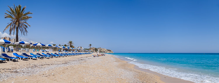 Villajoyosas strand med palmer och solstolar