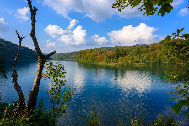 Blauer See zwischen den bewaldeten Hügeln von Plitvice