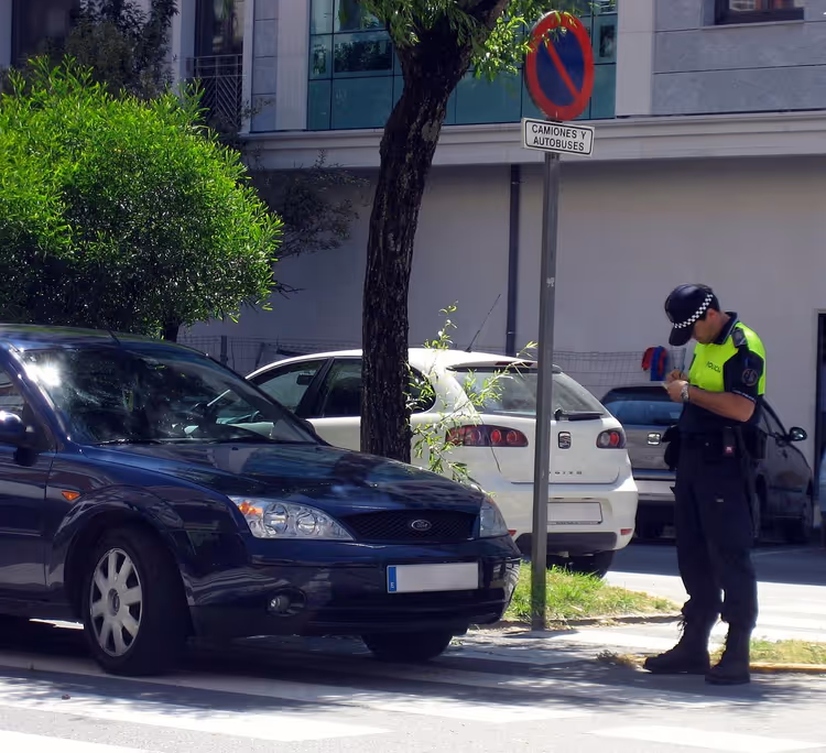 Polis som skriver böter till en förare vid ett övergångsställe