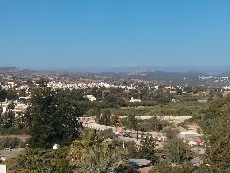 Panoramautsikt over Polis med grøntområder og fjell