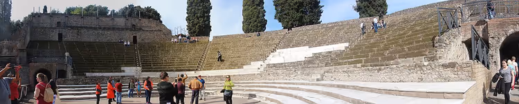 Steinseter i Det store teateret i Pompeii med turister