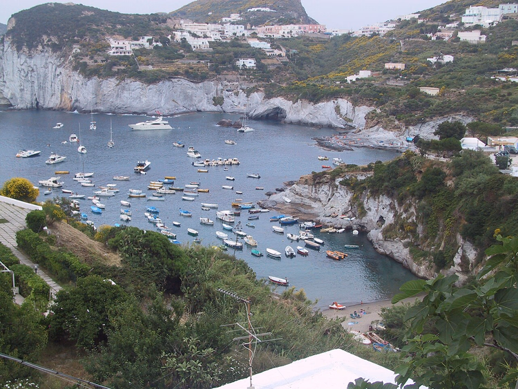 la baia di Cala Feola con barche e scogliere bianche