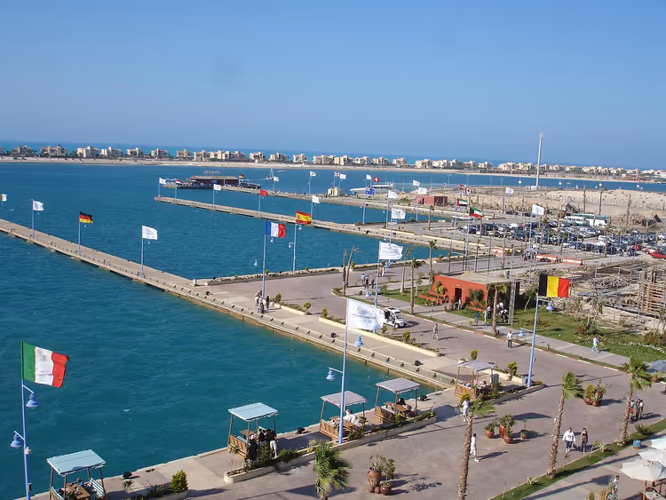 Turkuaz denizin kıyısında bayraklarla Porto Marina