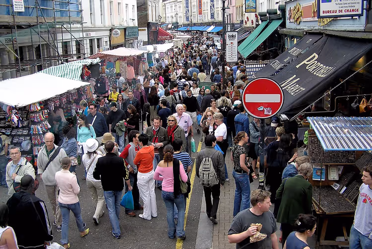 Een menigte shoppers tussen de kraampjes van Portobello Market