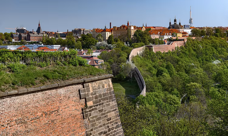 Kale duvarı ve yeşilliklerle Prag panoraması