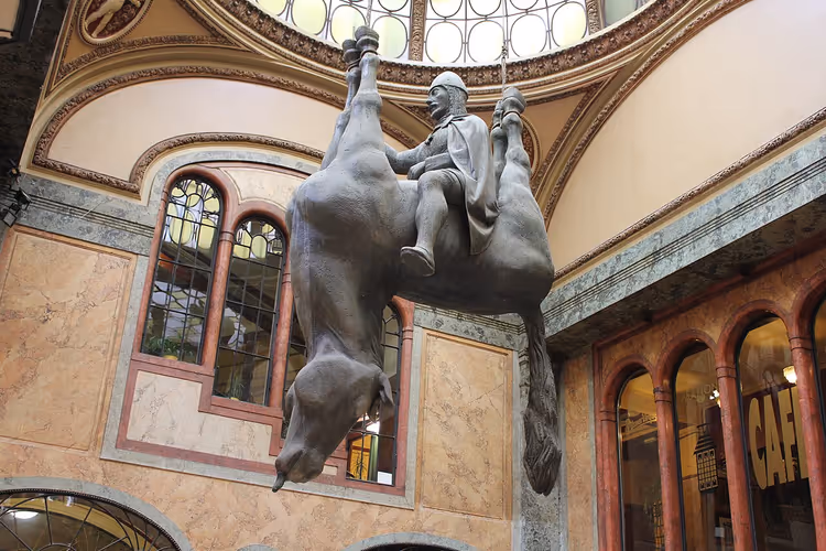 Ondersteboven rijdende ruiter op een paard in de Lucerna-passage