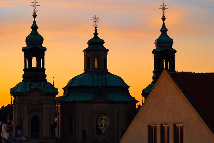 Koepels en torens van de Sint-Nicolaaskerk bij zonsondergang