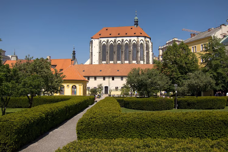 Gotische kerk met een hoog koor tussen een tuin