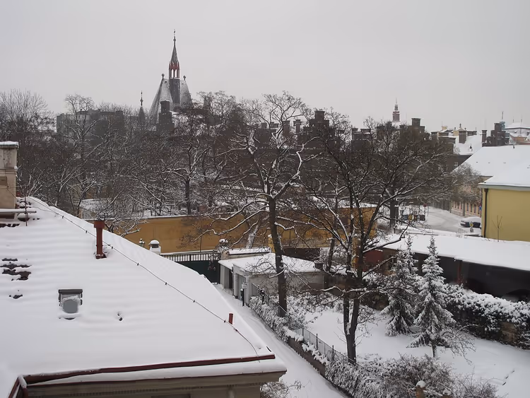 Snødekte tak i Praha og et kirkespir om vinteren