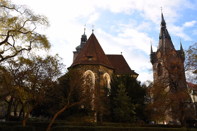 De Jindřišská-toren en een gotische kerk tussen de bomen