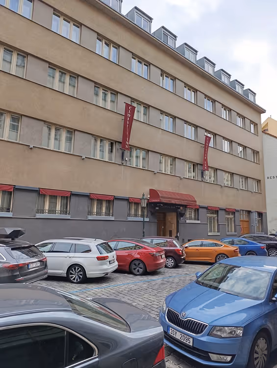 Фасад отеля Cloister Inn с красными баннерами и автомобилями
