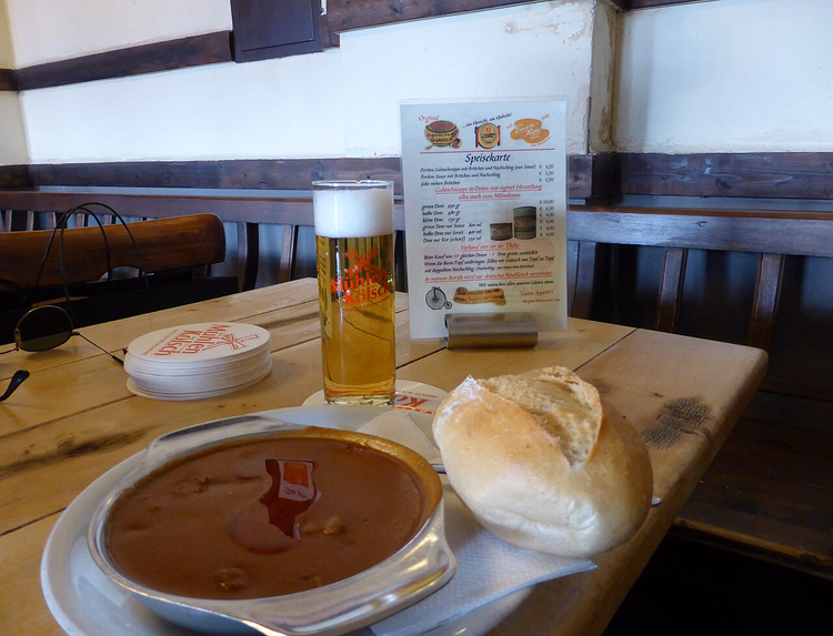 Glas Kölsch in einer Stange mit Gulasch
