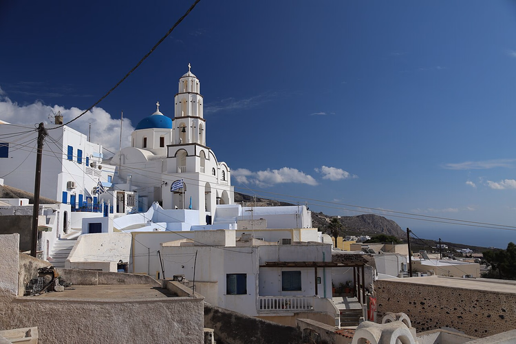Weiße Häuser und eine Kirche mit blauer Kuppel in Pyrgos