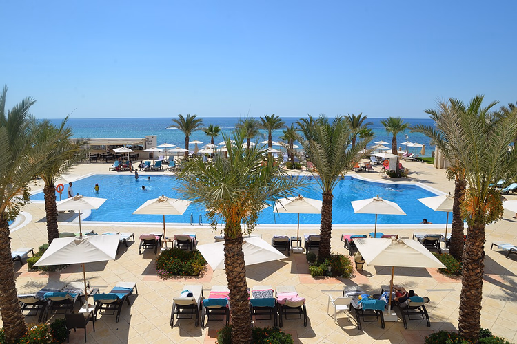 Hotellbasseng blant palmer ved havet