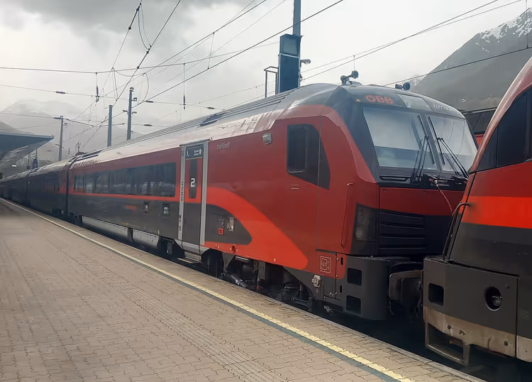 Roter Railjet 2 am Bahnsteig in den Bergen