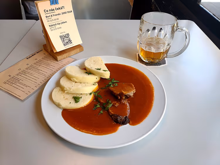 Fleisch in Soße mit Knödeln und einem Krug Bier