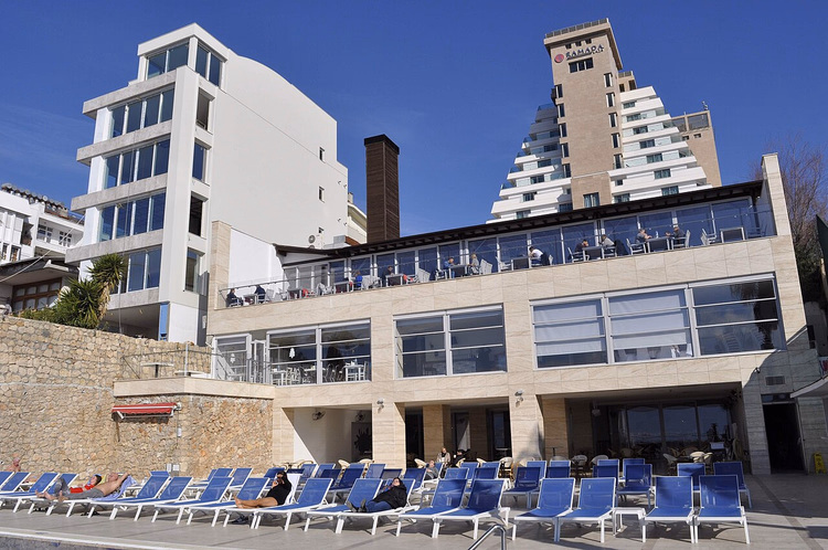 Ramada Hotel-tårnet over bassenget med solsenger