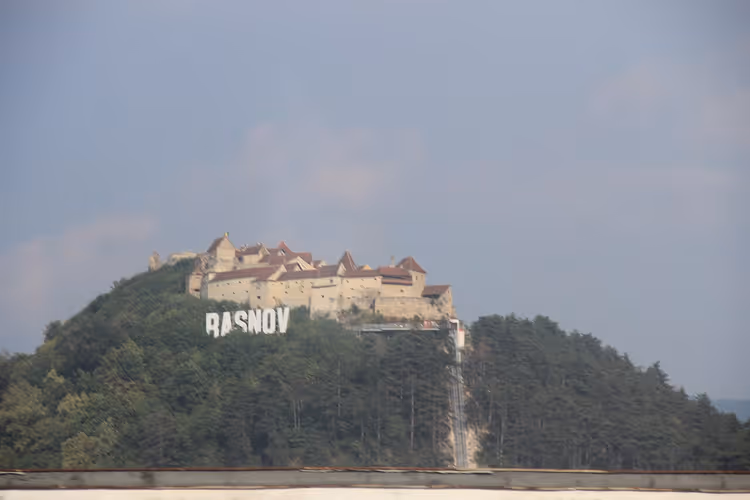 Râșnov festning på en ås med RASNOV-skilt