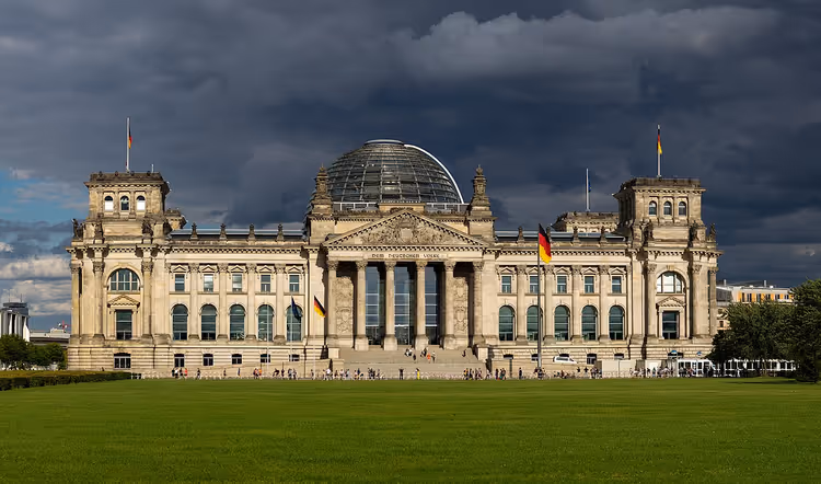 Reichstagsgebäude in Berlin mit Kuppel und grüner Wiese