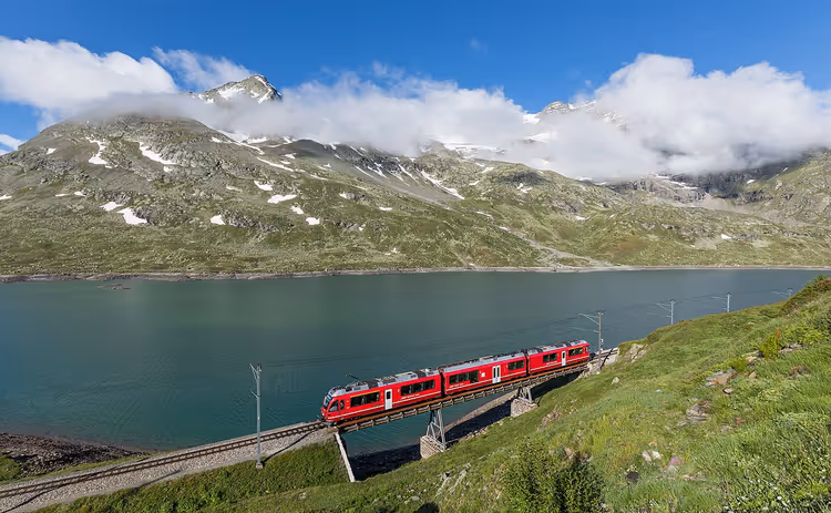 Roter Allegra-Zug auf einem Viadukt an einem Bergsee