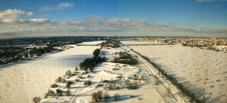 Vinterpanorama med snødekte marker og byen