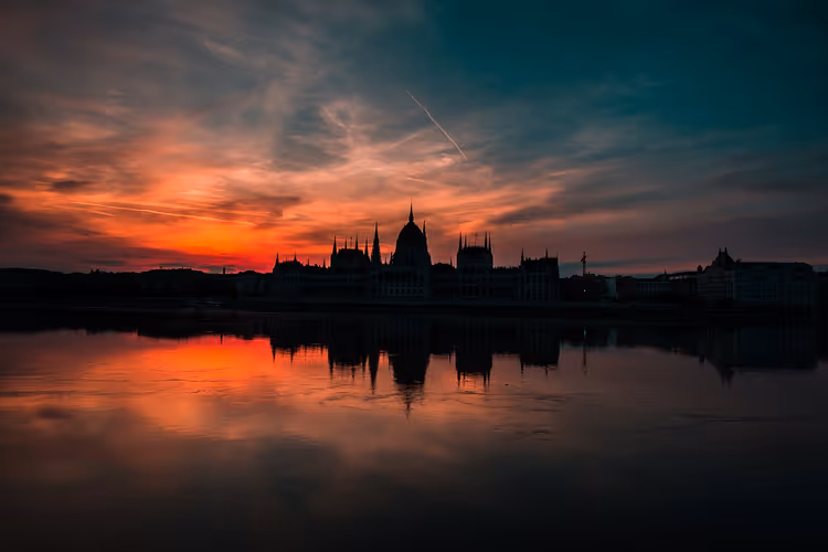 Silhueta do Edifício do Parlamento Húngaro ao pôr do sol sobre o Danúbio