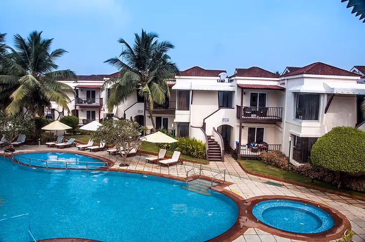 Resortpool mit Gebäuden und Palmen in Goa