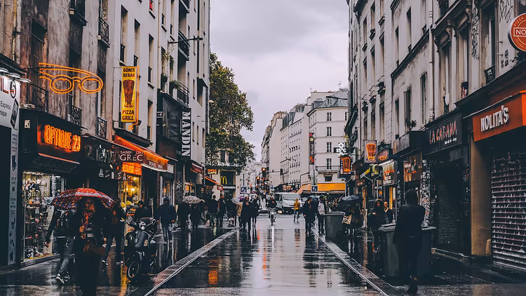 Verregnete Einkaufsstraße in Paris mit Geschäften