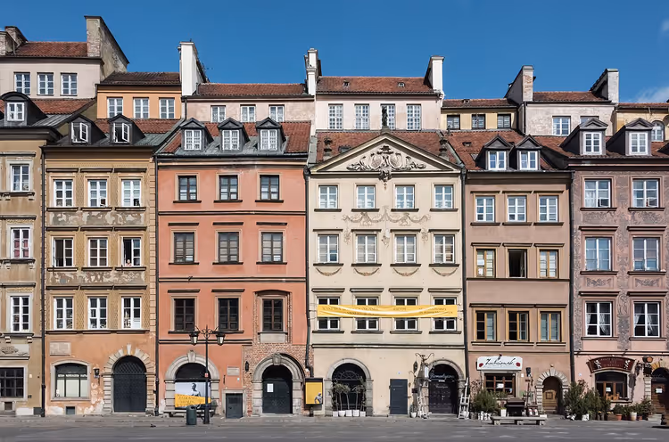 Fargerike bygårder på Markedsplassen i Warszawa med et gult banner