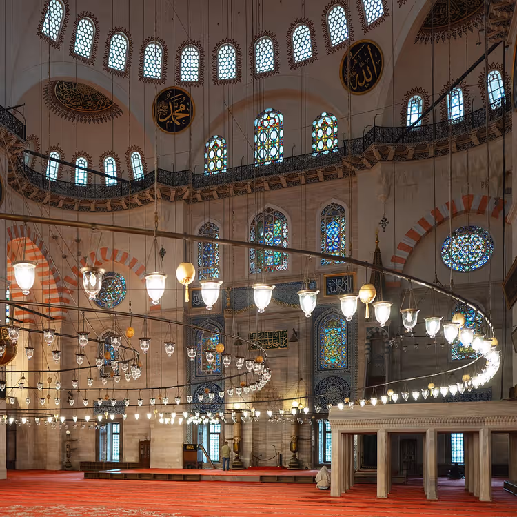 الجزء الداخلي من مسجد السليمانية مع المصابيح والسجاد الأحمر