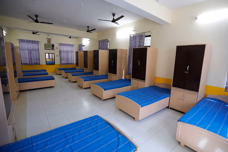Sıra sıra yataklar ve dolaplarla paylaşımlı hostel koğuşu