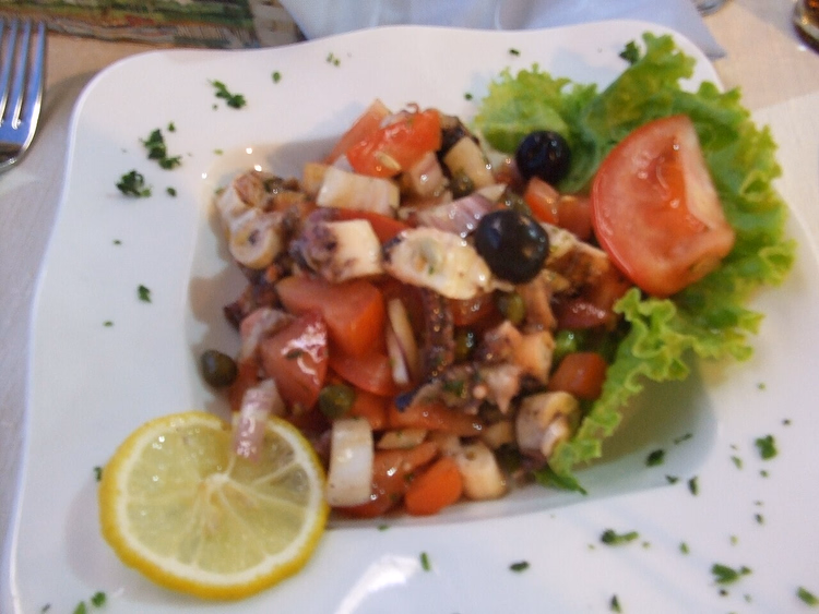 Octopus salad with tomatoes, olives and lemon