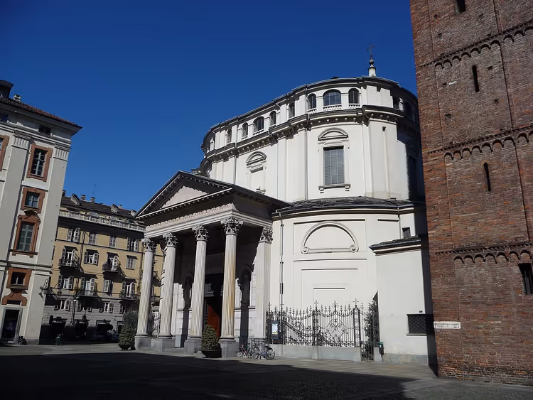 белая церковь с портиком и колоннами на площади