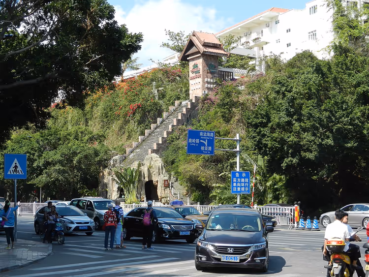 Straatverkeer in Sanya met auto's en scooters