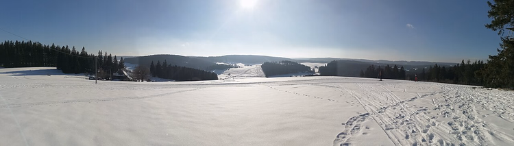 Verschneite Schwarzwaldhügel mit einer Loipe bei Schönwald