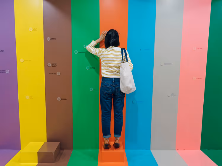 Посетитель у разноцветной стены в Color Factory