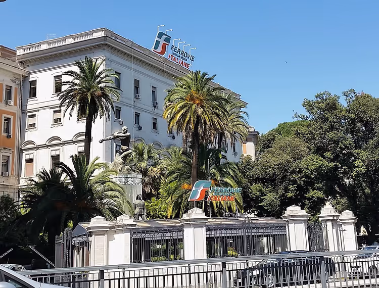 Sede delle Ferrovie Italiane con palme e insegne