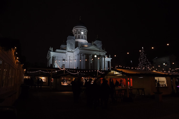 Kathedraal bij nacht en kerstmarkt op het plein