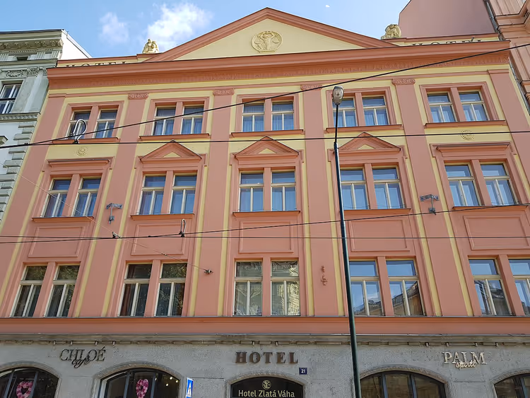 Roze gevel van Hotel Zlatá Váha met zijn uithangbord