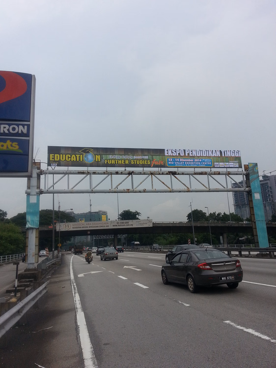 Autobahn in Malaysia mit einem über die Straße gespannten Banner