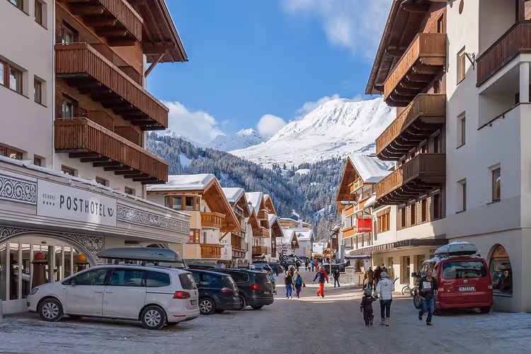Verschneite Straße in Serfaus mit Hotels und Bergen