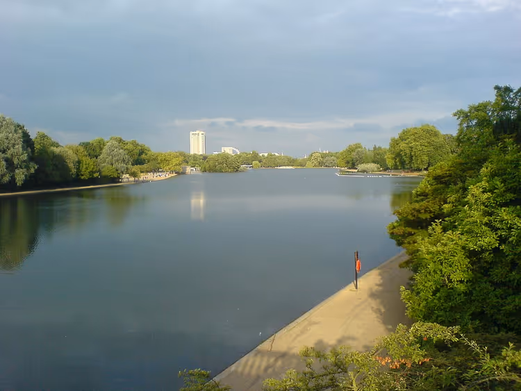Hyde Park'ta set duvarı ve ağaçlarla çevrili Serpentine gölü
