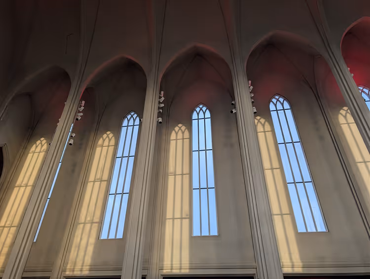 Hoge boogramen en schaduwen in een kerkinterieur