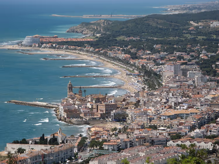 Panorama von Sitges mit einer Kirche auf der Landzunge und Stränden