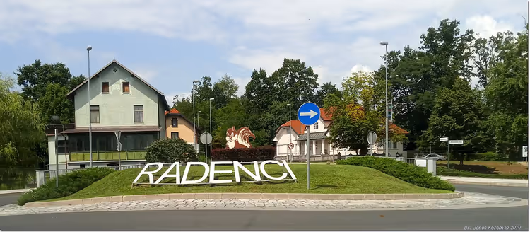 Plaatsnaambord van Radenci met bloemen en huizen